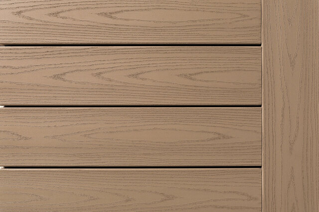 Close-up of TimberTech Harvest Collection boards in Brownstone, a warm taupe with embossed grain, with a picture-frame border board on the right.