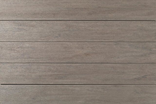 Close-up of TimberTech Porch Collection boards in Coastline, a pale weathered gray-tan with soft grain.