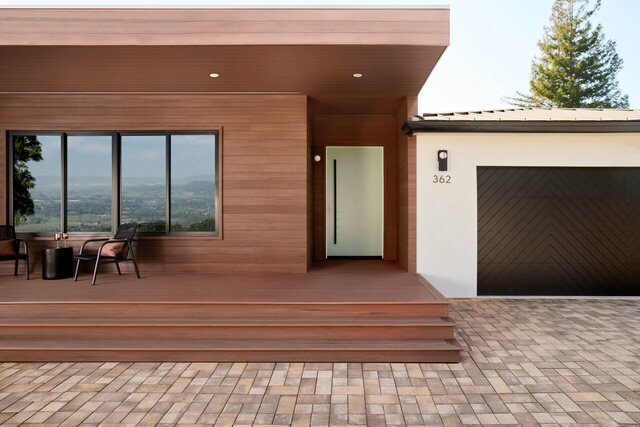 A modern house with TimberTech Vintage Collection cladding in Mahogany on the walls, soffit, and front steps, photographed by TimberTech.