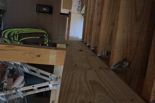 Row of metal rafter ties fastening each roof joist to the beam on a covered porch build